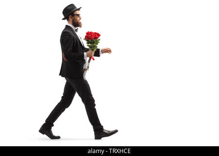 Volle Länge Profil Schuß eines bärtigen Mann im Anzug mit einem Strauß roter Rosen auf weißem Hintergrund Stockfoto