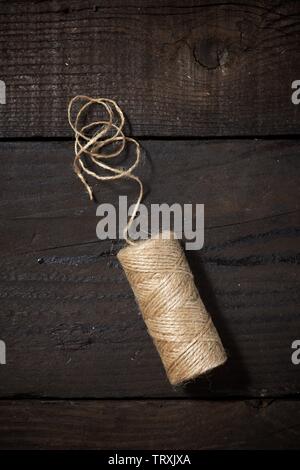 Rolle mit Seil auf einem Holztisch. Stockfoto