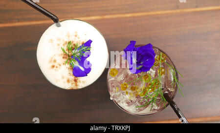 Zwei Gläser trinken, Kaffee und italienische Soda Menü auf den Tisch im Café dekorieren mit Erbse Blumen und grünes Gras Stockfoto