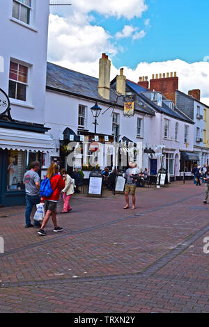 Personen, die sich ausserhalb der Anchor Inn, einem traditionellen Public House in alten Fore Street, Sidmouth. Andere wandern durch die Geschäfte zu erkunden. Stockfoto