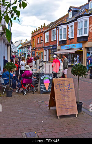 Alte Fore Street, eine der Haupteinkaufsstraßen der beliebte Badeort Sidmouth. Käufer queuing Home zu kaufen - aus Eis. Stockfoto