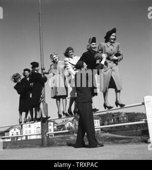 Frauen der 40er Jahre. Sieben junge Frauen balancieren auf einem Zaun. Ein Mann mit einer Hand. Bild in der Stadt Borås, wo das Wort ist, dass es einen Mangel an einzelne Menschen genommen. Nur eine freie und single Mann auf sieben Frauen. Schweden 1942. Foto Kristoffersson Ref. A 42-5 Stockfoto