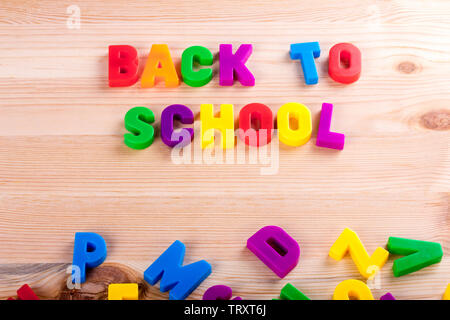 Zurück zu Schule Text mit magnetischen farbigen Buchstaben über eine hölzerne Schule Tabelle geschrieben Stockfoto