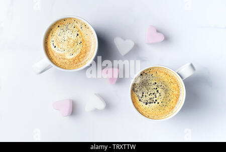 Romantische desk top mit zwei Tassen Kaffee und Rosa herzförmige Marshmallows. Ansicht von oben. Kopieren Sie Platz. Stockfoto