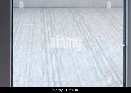 Längs- Crack auf dem Glas. Kunststoff Fenster durch Risse beschädigt. Stockfoto