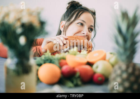 Junge Frau auf einer Diät erlag der Versuchung und leidenschaftlich beißt eine lange weiße knusprige Brot. Das Konzept der Diät, gesunde Ernährung und die Ablehnung von Ba Stockfoto