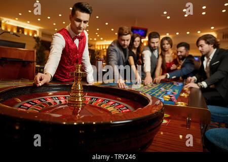 Der Croupier hält eine Kugel in einem Casino in seiner Hand. Das Spielen in einem Casino. Stockfoto