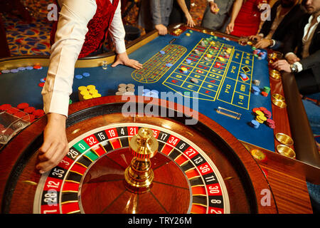 Der Croupier hält eine Kugel in einem Casino in seiner Hand. Das Spielen in einem Casino. Stockfoto