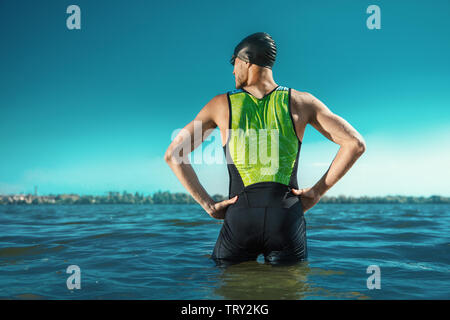 Professioneller Triathlet schwimmen in River's offene Wasser. Mann, Schwimmen Ausrüstung üben Triathlon auf dem Strand, in der Sommertag. Konzept der gesunden Lebensstil, Sport, Action, Bewegung und Bewegung. Stockfoto