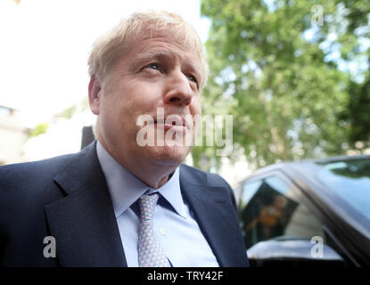 Bild zeigt: Boris Johnson kommt für seine Führung starten in Pall Mall heute mit Karikatur von ihm im Hintergrund pic von Gavin Rodgers/Pixel 8000 Stockfoto