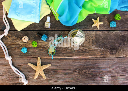 Damen Sommer Kleider und Accessoires auf alten Holz- Hintergrund. Ansicht von oben, flach. Stockfoto