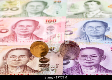 Thai Baht Münzen auf dem Hintergrund von Banknoten Stockfoto