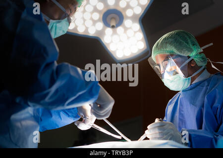 Asiatische Arzt und einem Assistenten im Operationssaal für chirurgische venöse Gefäßchirurgie Klinik im Krankenhaus. Stockfoto