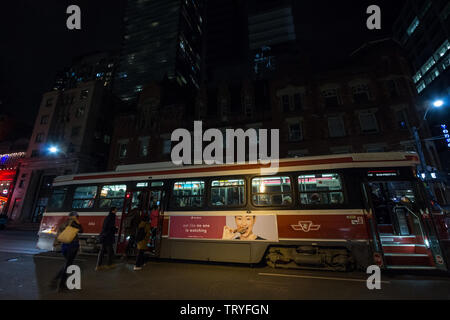 TORONTO, KANADA - 14. NOVEMBER 2018: Menschen, die eine alte Straßenbahn in der Innenstadt von Toronto, Ontario in der Nacht. Toronto Transit Kommission ist die operato Stockfoto