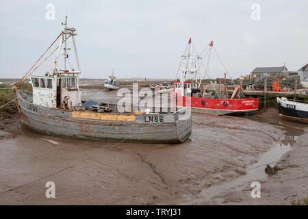 Hölzerne Fischerboote bei Ebbe an brancaster Staithe Quay, im Dorf Brancaster Staithe auf die Küste von Norfolk in England Stockfoto