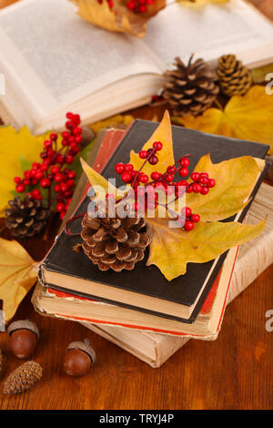 Bücher und Herbstlaub auf Holztisch close-up Stockfoto