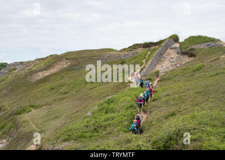 Gruppe der Wanderer Wandern entlang der Pembrokeshire Coast Path an der Broad Haven in Pembrokeshire, Wales Stockfoto