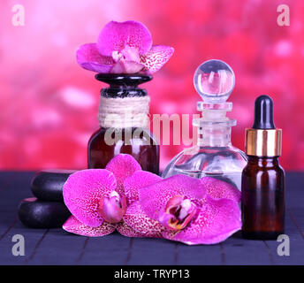 Wunderschöne Spa mit Orchidee auf Bambus Tisch auf rotem Hintergrund Stockfoto