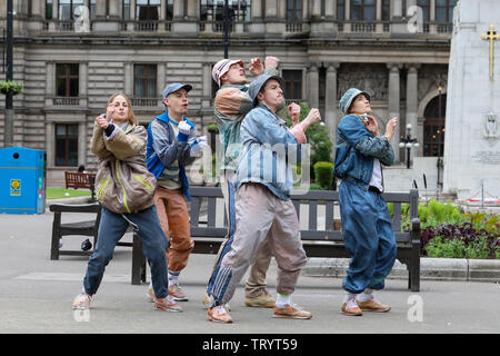 Glasgow, UK. 13. Juni 2019. Mittag Massen in Glasgows George Square Waren zum freien Tanz zeigen, indem Sie die Darsteller von "ÖDLAND" Dance Troupe, eine hohe Energie Theater anlässlich des 25. Jahrestages der Abriss von Grimethorpe Colliery in South Yorkshire und 30 Jahre seit dem Aufstieg der BRITISCHEN rave Kultur behandelt. Der schottischen Premier ist in Glasgow's Straßenbahn Theater am 14. und 15. Juni. Credit: Findlay/Alamy leben Nachrichten Stockfoto