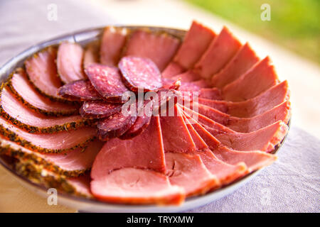 Kalt geräucherte Fleisch Platte mit in Scheiben geschnittenen Schinken, Salami, Speck, Schweinekoteletts. Verschiedene Arten von Fleisch auf den Brettern. Fleisch Antipasti Teller. Traditio Stockfoto