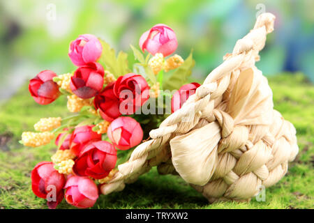 Kleine Stroh Hut mit Blumen, auf grünem Moos Stockfoto