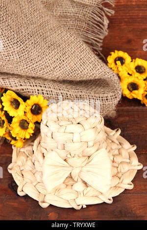 Kleine Stroh Hut mit Blumen, auf hölzernen Tisch Stockfoto
