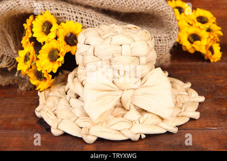 Kleine Stroh Hut mit Blumen, auf hölzernen Tisch Stockfoto
