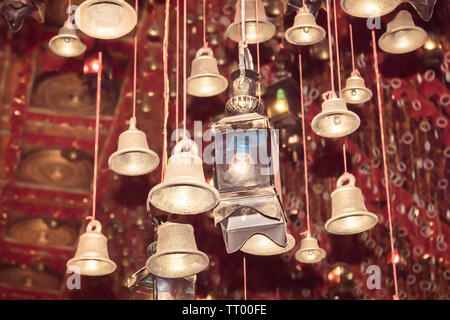 Goldene Glocken mit Gruß lucky Wort auf Red Ribbon in Dakshineswar Kali Tempel Kolkata. Pilgern die Menschen wollen, und hängen Sie es am Seil für Beten. Merry chri Stockfoto