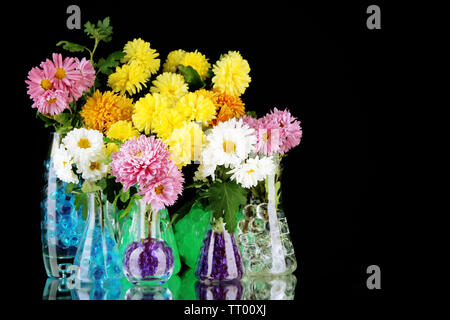 Schönen Blumen in Vasen mit hydrogel isoliert auf Schwarz Stockfoto