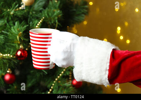 Santa mit Tasse in seiner Hand, auf einem hellen Hintergrund Stockfoto