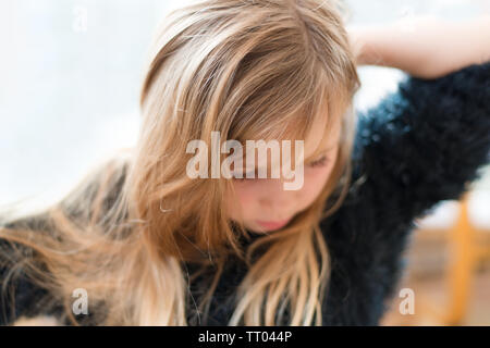 Junge hübsche Mädchen, ihr langes Haar bürsten in weichen verträumt Fokus Stockfoto