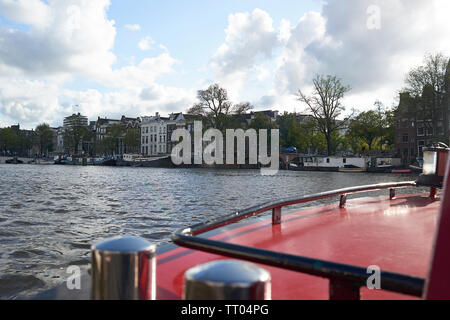 Gruppe von Menschen auf einem Boot genießen der Kanäle im Zentrum von Amsterdam. Stockfoto