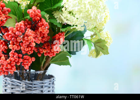 Blumen und Beeren in der Vase, auf Holztisch, auf hellen Hintergrund Stockfoto