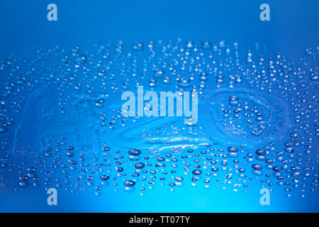 H2O auf Wassertropfen auf blauem Hintergrund geschrieben Stockfoto