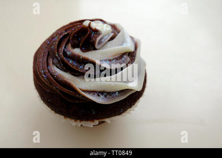 Chocolate Cupcake mit Vanille und Schokolade butter Puderzucker und gekrönt mit essbaren Glitter Stockfoto