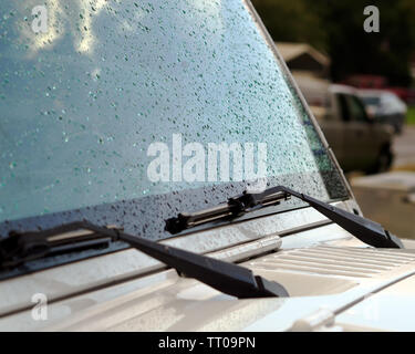 Regentropfen auf der Außenseite der Windschutzscheibe eines weißen Jeep Wrangler. Stockfoto