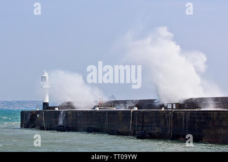 Wellen über den Hafen von Penzance Wand- und Leuchtturm, Cornwall, England, UK. Stockfoto