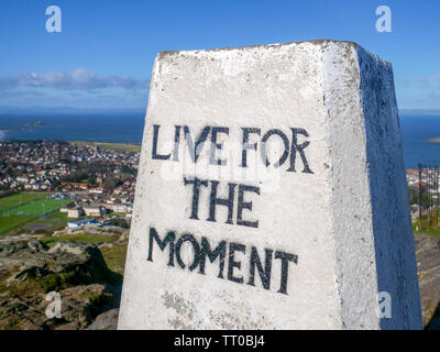 "Lebe für den Augenblick' auf der Triangulation Säule auf der Oberseite des North Berwick, East Lothian, Schottland, Großbritannien. Stockfoto