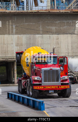 Rote und gelbe redi-Beton Lkw verlassen den Ozean Zement Depot auf Granville Island in Vancouver, British Columbia Stockfoto