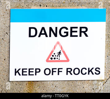 Gefahr Schild halten, von den Felsen aus Großbritannien Stockfoto