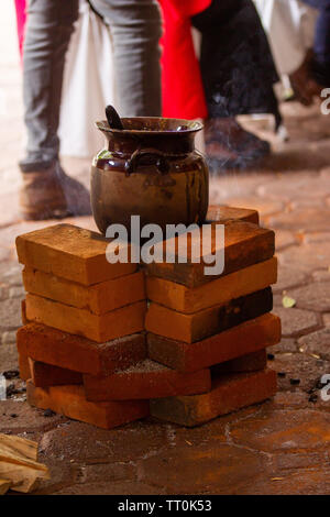 Eine mexikanische handgemachtes Tongefäß auf einem drei Stein Herd mit Holz gefeuert Stockfoto