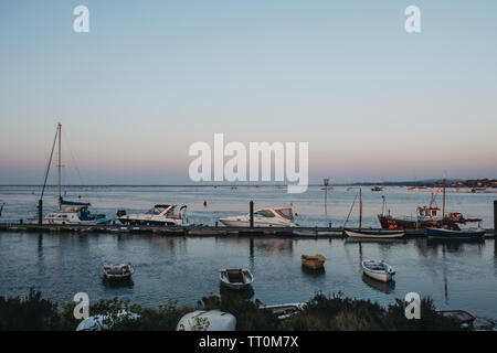 Wells-next-the-Sea, Großbritannien - 20 April, 2019: Boote durch die angelegte Wells-next-the-Sea Port während der blauen Stunde. Brunnen ist eine Stadt am Meer und Hafen in Norfolk, Großbritannien Stockfoto