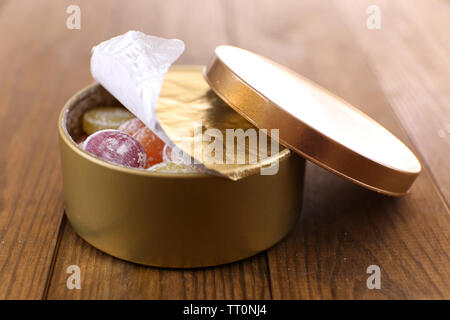 Süße Bonbons in Metall, Holz- Hintergrund Stockfoto