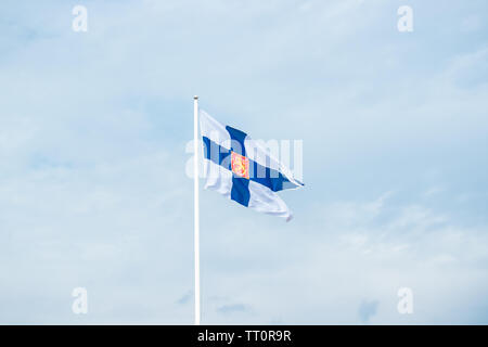 Staat Fahne von Finnland mit nationalen Wappen gegen den blauen Himmel Stockfoto
