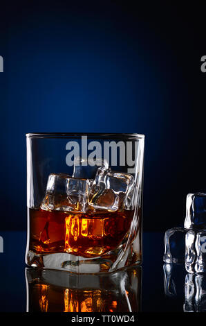 Whiskey im Glas und Eiswürfel mit Reflexionen Stockfoto