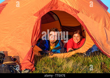 Paar genießt die Abendsonne vor einem Zelt Stockfoto