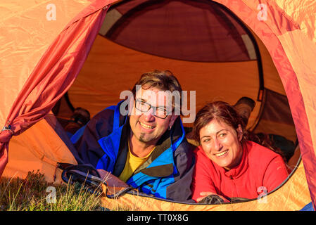 Paar genießt die Abendsonne vor einem Zelt Stockfoto