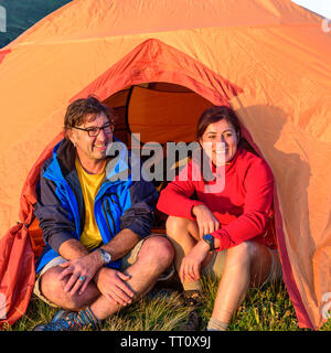 Paar genießt die Abendsonne vor einem Zelt Stockfoto