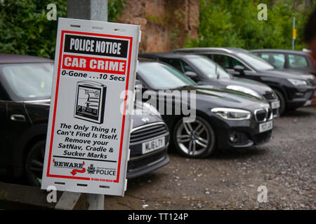 Diebstahl aus dem Auto Kriminalität, Warnschild Vorsicht; Polizei Hinweis für Autofahrer auf einem Parkplatz in Manchester, Großbritannien Stockfoto