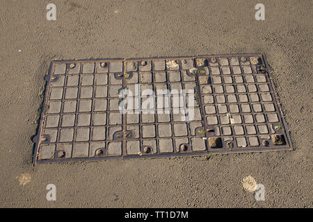 Rechteckige Gusseisen Schachtdeckel in Parkplatz, Edinburgh, Schottland Stockfoto